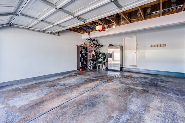 garage with stainless steel fridge and a garage door opener