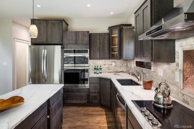 713 Rudi Ln, Golden, CO 80403 - kitchen featuring wall chimney range hood, stainless steel appliances, light stone counters, tasteful backsplash, and glass insert cabinets