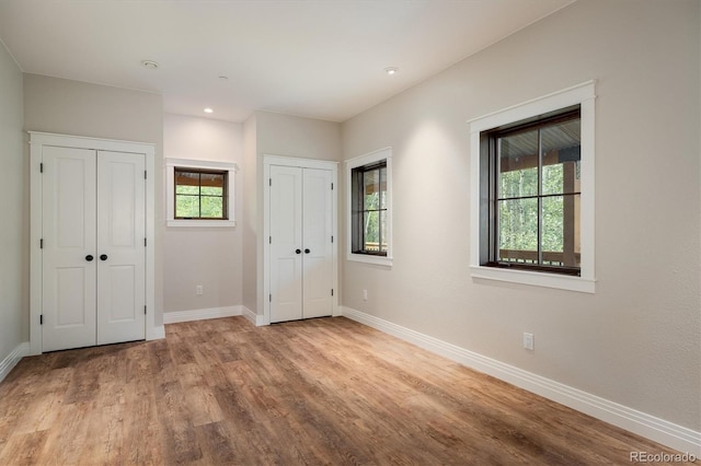 713 Rudi Ln, Golden, CO 80403 - unfurnished bedroom featuring two closets, multiple windows, wood finished floors, and recessed lighting