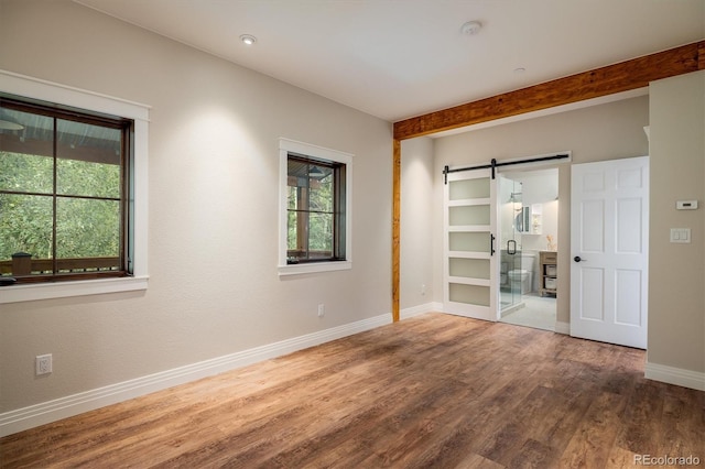 713 Rudi Ln, Golden, CO 80403 - empty room with a barn door, wood finished floors, and a smoke detector