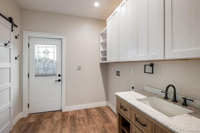 713 Rudi Ln, Golden, CO 80403 - laundry room with hookup for a washing machine, cabinet space, electric dryer hookup, a barn door, and wood finished floors