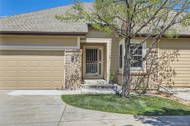 6114 Salvia Ln, Arvada, CO 80403 - view of front of property featuring concrete driveway, roof with shingles, a garage, and brick siding