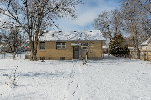 view of snow covered back of property