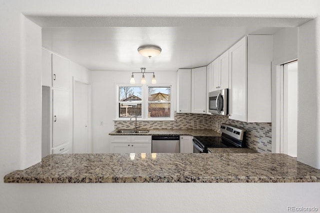 kitchen featuring sink, backsplash, stainless steel appliances, light stone counters, and white cabinets