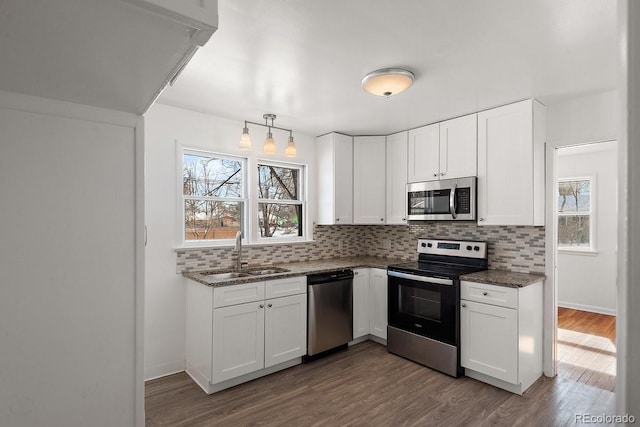 kitchen featuring sink, decorative light fixtures, stainless steel appliances, and white cabinets