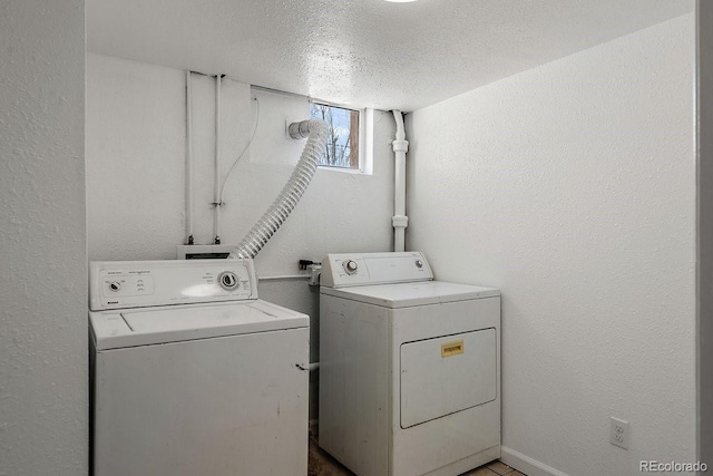 laundry area featuring washing machine and dryer and a textured ceiling