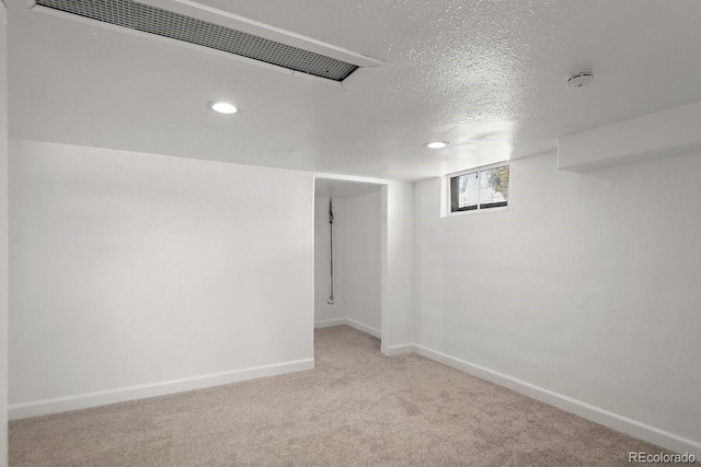 basement with light colored carpet and a textured ceiling