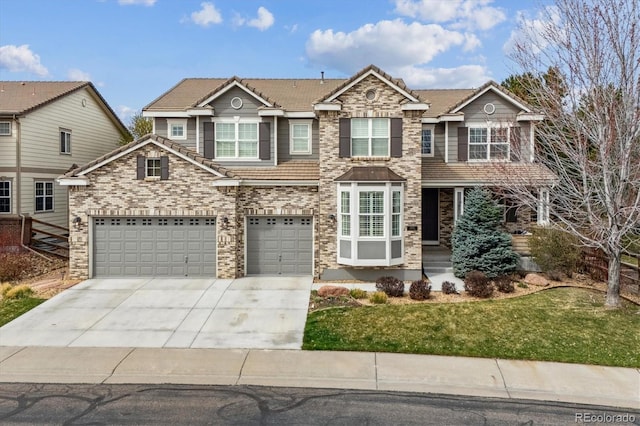 view of front of property with a tiled roof, driveway, a front yard, and a garage