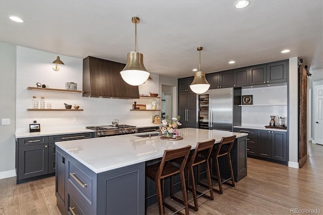 kitchen with range, open shelves, custom exhaust hood, a sink, and built in fridge