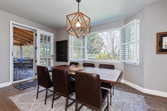 dining space featuring baseboards, wood finished floors, and a healthy amount of sunlight