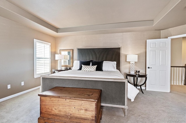 bedroom featuring a tray ceiling, carpet flooring, and baseboards