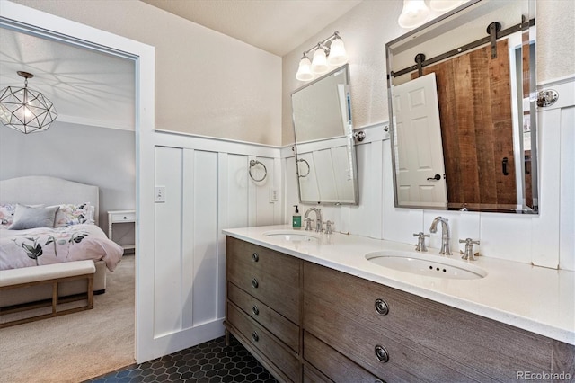bathroom featuring a decorative wall, double vanity, a sink, and wainscoting