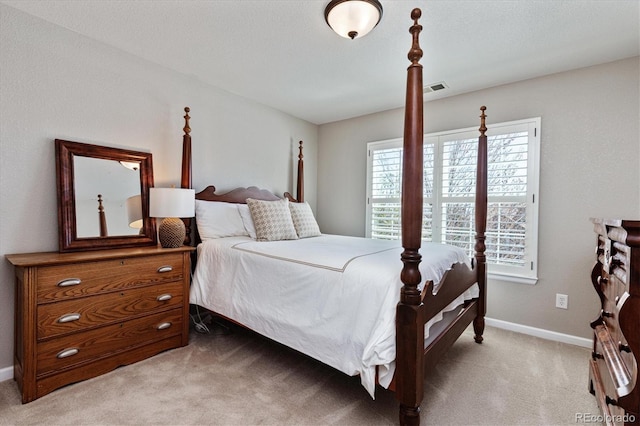 bedroom featuring visible vents, baseboards, and light carpet