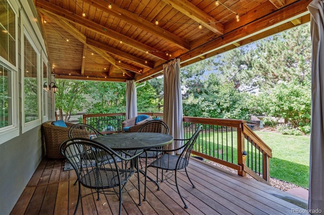 deck with a yard and outdoor dining area