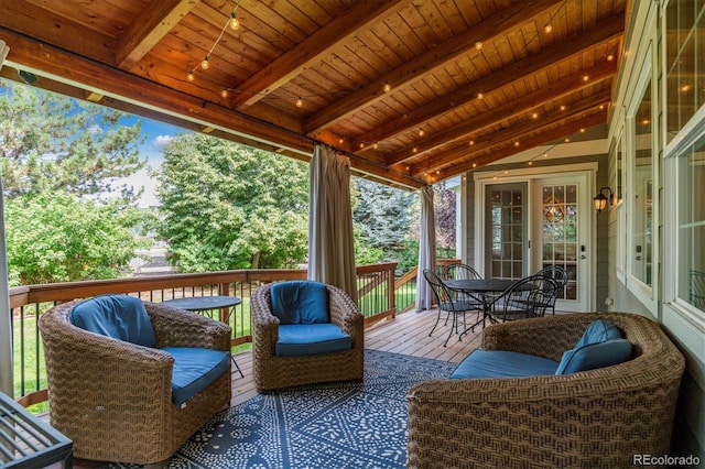 sunroom featuring beam ceiling and outdoor dining space