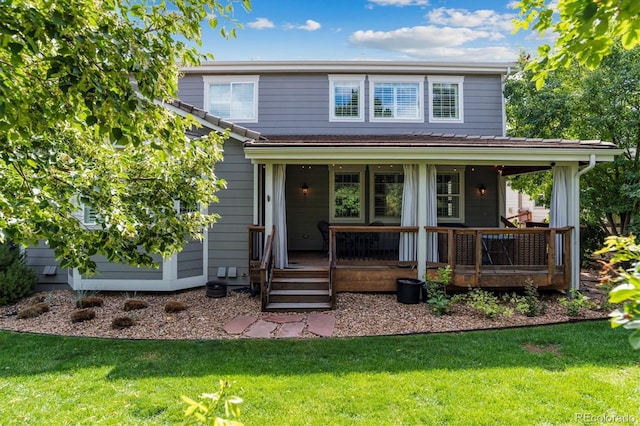 back of property with a yard and covered porch