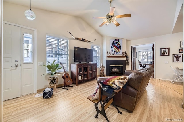 living room with vaulted ceiling, ceiling fan, plenty of natural light, and light hardwood / wood-style floors