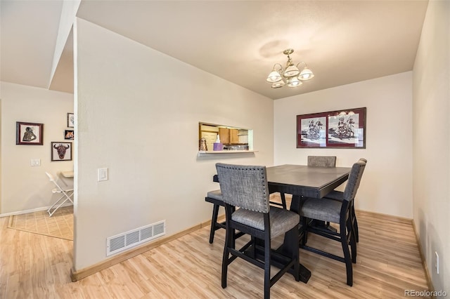 dining area featuring an inviting chandelier and light hardwood / wood-style floors