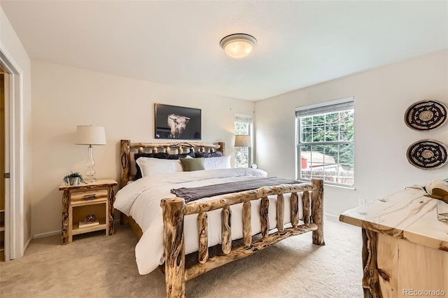 bedroom with baseboards and light colored carpet