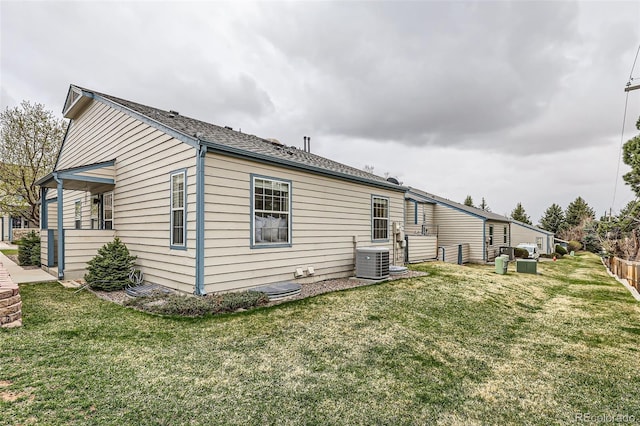 view of side of property featuring central AC unit and a yard