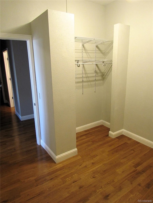 walk in closet with wood finished floors