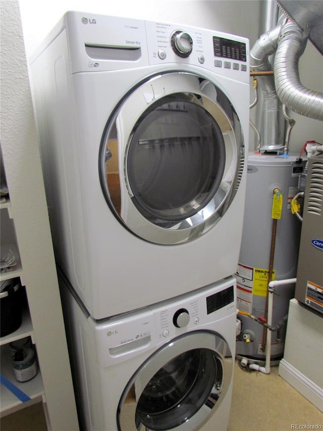 clothes washing area with gas water heater, laundry area, and stacked washer / dryer