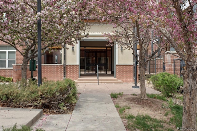 property entrance featuring brick siding and stucco siding