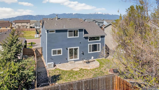 1899 Woodpark Dr, Colorado Springs, CO 80951 - back of property featuring a patio area, a mountain view, a fenced backyard, roof with shingles, and a cooling unit