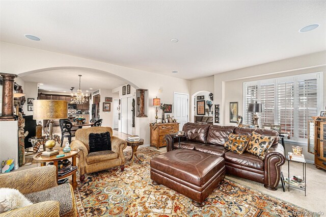 carpeted living room featuring a notable chandelier