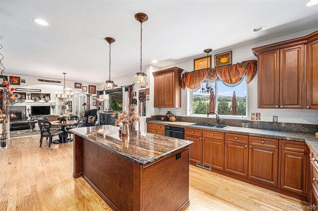 kitchen with black dishwasher, a notable chandelier, light hardwood / wood-style floors, a center island, and sink