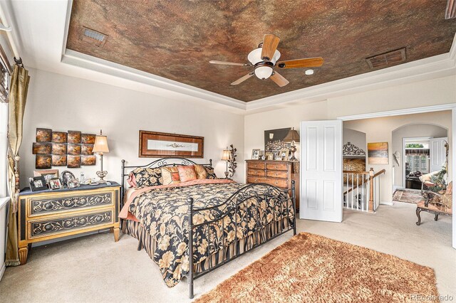 bedroom with ceiling fan, a raised ceiling, and carpet floors