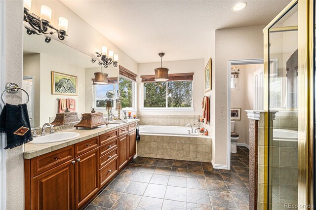 full bathroom featuring independent shower and bath, toilet, a textured ceiling, and vanity