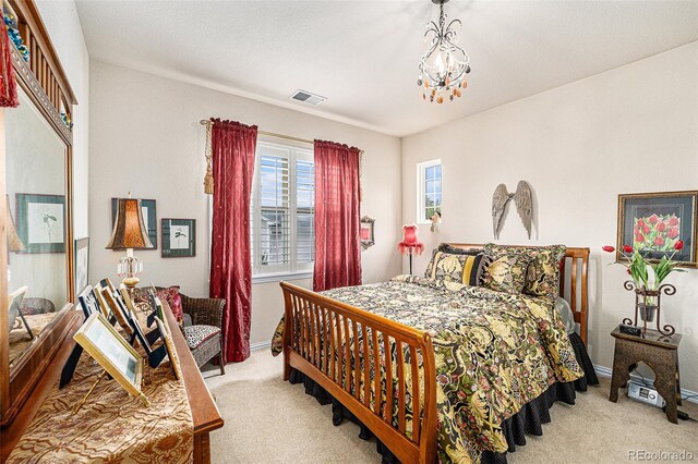 carpeted bedroom featuring an inviting chandelier