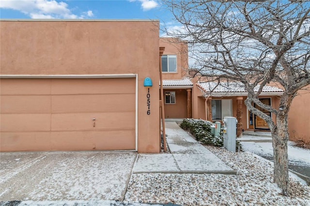 pueblo revival-style home with a garage