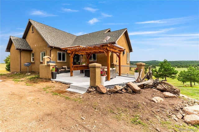 view of side of home featuring a pergola and a patio area