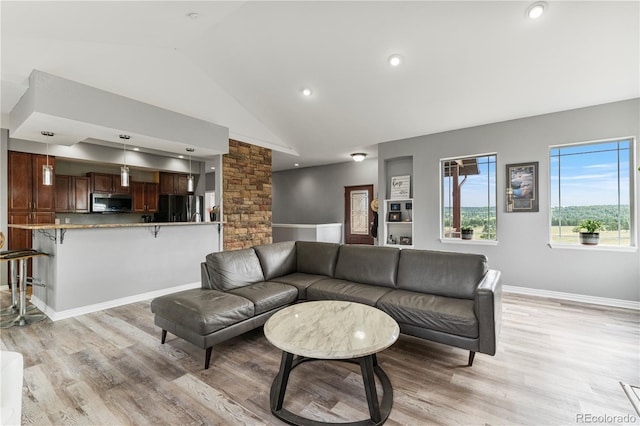 living room featuring light hardwood / wood-style floors and vaulted ceiling