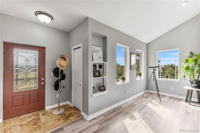 foyer with light hardwood / wood-style floors and vaulted ceiling