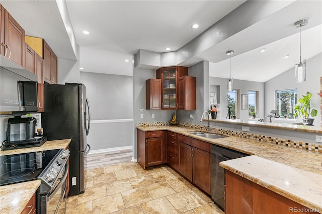 kitchen featuring appliances with stainless steel finishes, decorative light fixtures, sink, light wood-type flooring, and light stone countertops