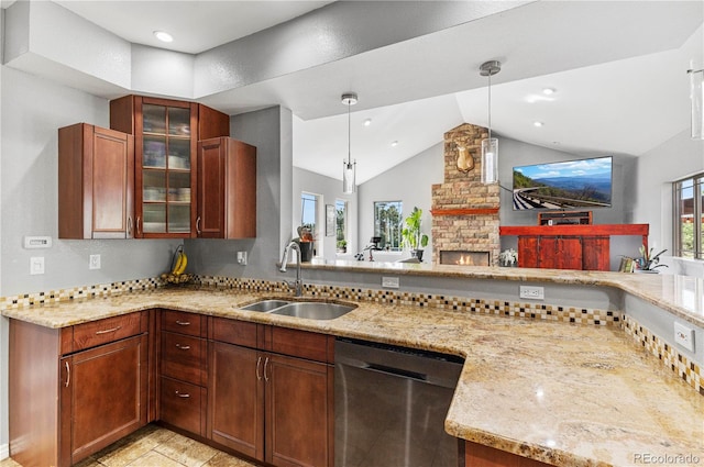 kitchen featuring stainless steel dishwasher, vaulted ceiling, plenty of natural light, and a fireplace