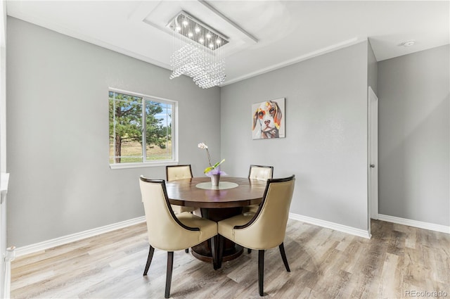 dining area featuring an inviting chandelier and light hardwood / wood-style flooring