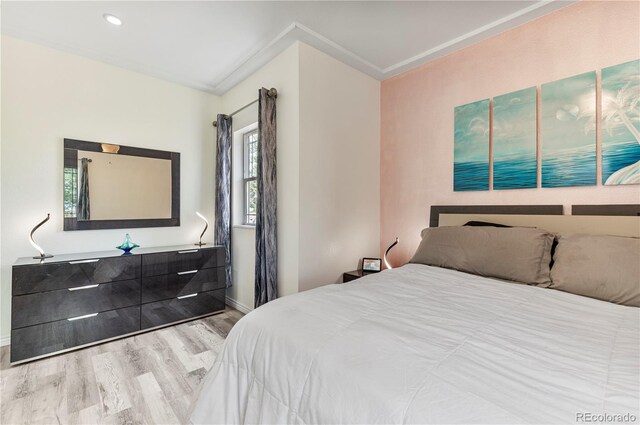 bedroom with light wood-type flooring and ornamental molding