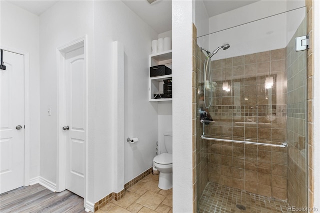 bathroom with walk in shower, hardwood / wood-style floors, and toilet