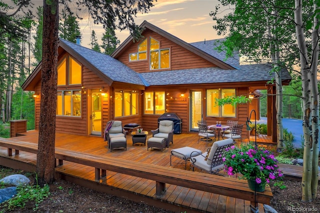 wooden terrace featuring outdoor dining area and grilling area