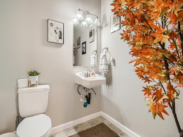 bathroom featuring sink, toilet, and tile patterned flooring