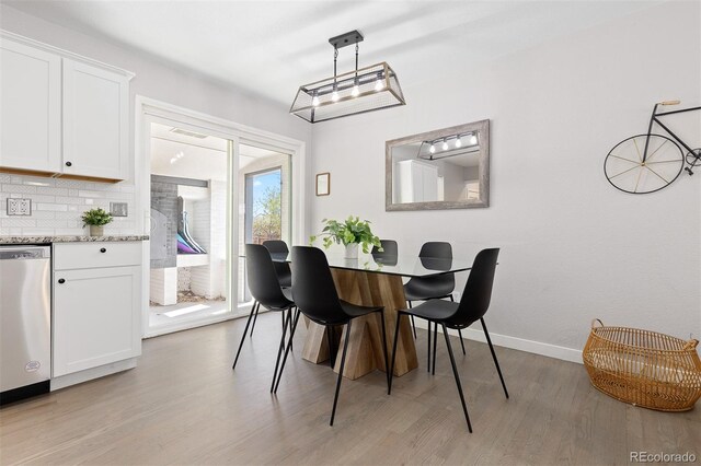 dining space with light wood-style flooring and baseboards