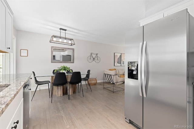 dining room featuring baseboards and light wood-style floors