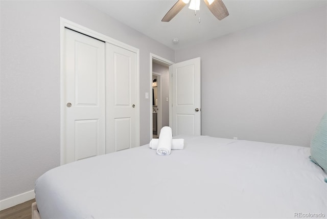 bedroom featuring wood finished floors, a closet, baseboards, and ceiling fan