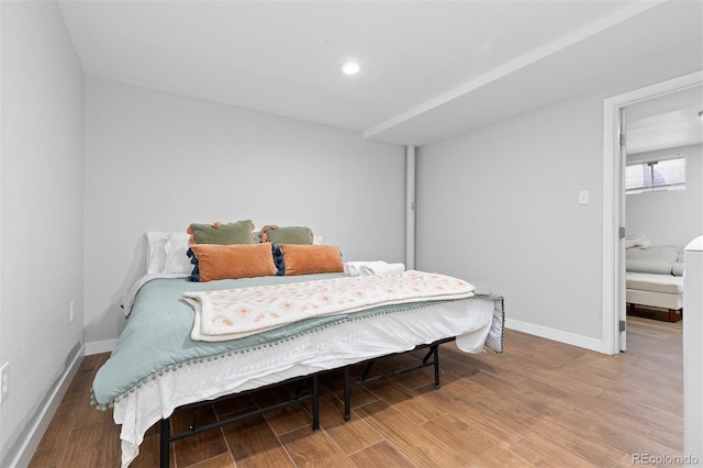 bedroom featuring baseboards, wood finished floors, and recessed lighting