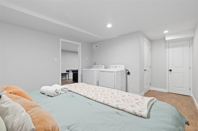 bedroom featuring wood finished floors, washer and clothes dryer, visible vents, and recessed lighting