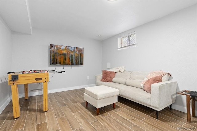 living area with baseboards and wood finished floors